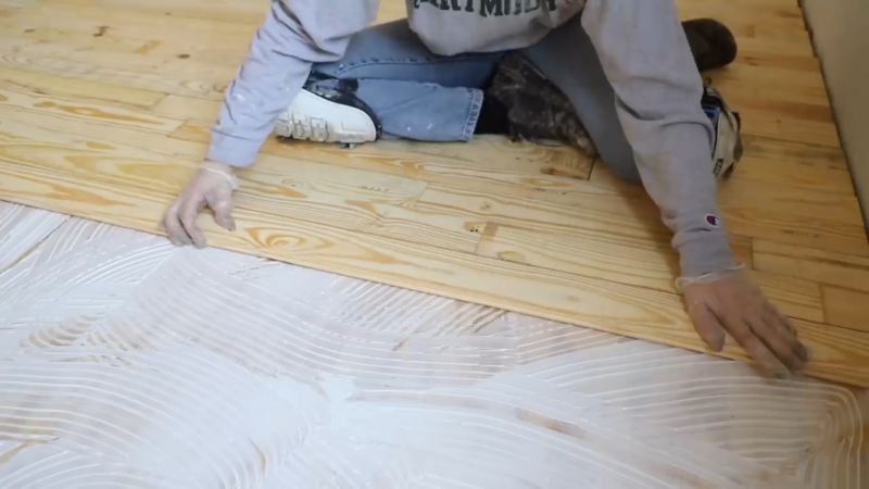 A Person Laying Down Wooden Flooring as Part of A Home Improvement Project