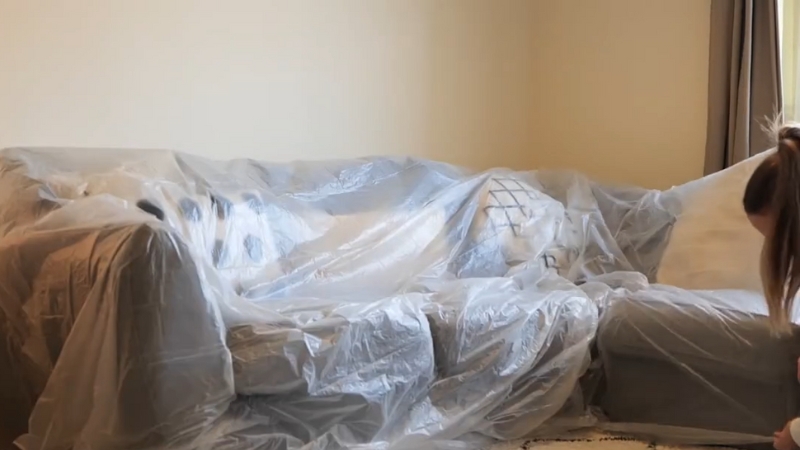 A Plastic Sheet Covers a Sofa to Protect It from Dust During a Long Absence