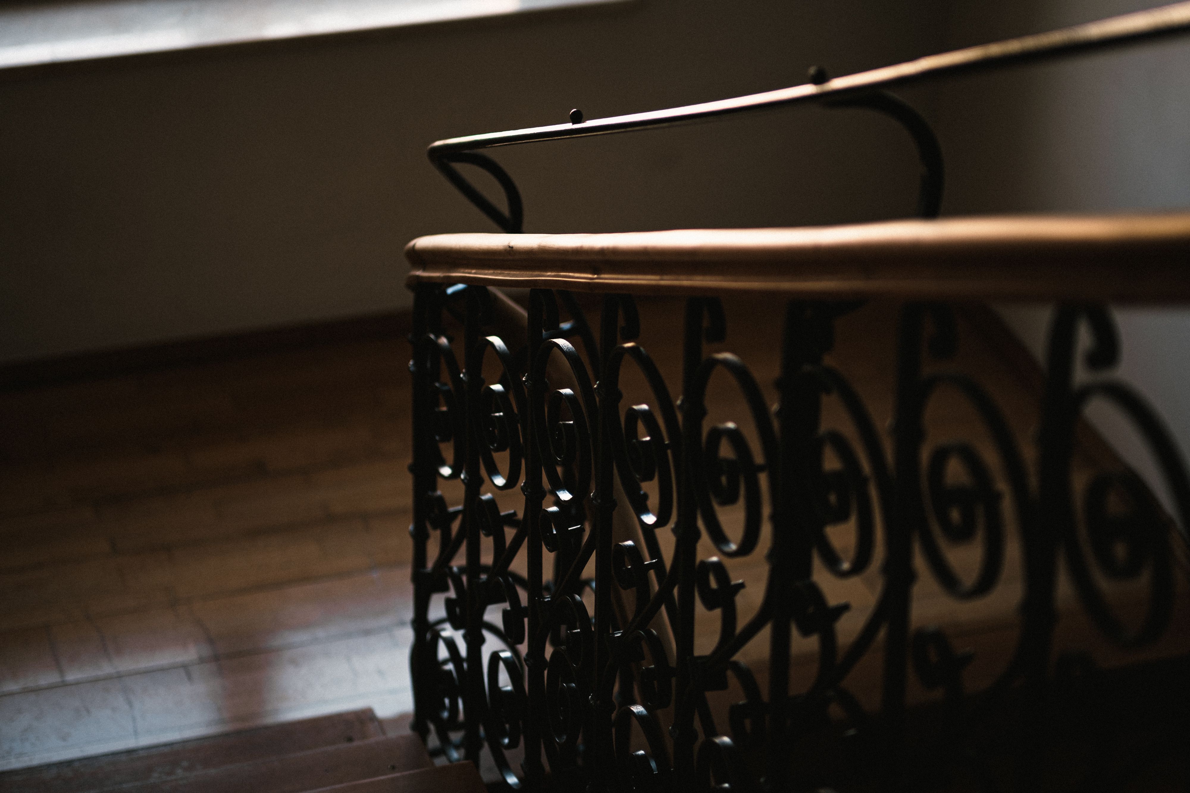 Close-up of a spiral staircase with ornate metal railing and wooden steps