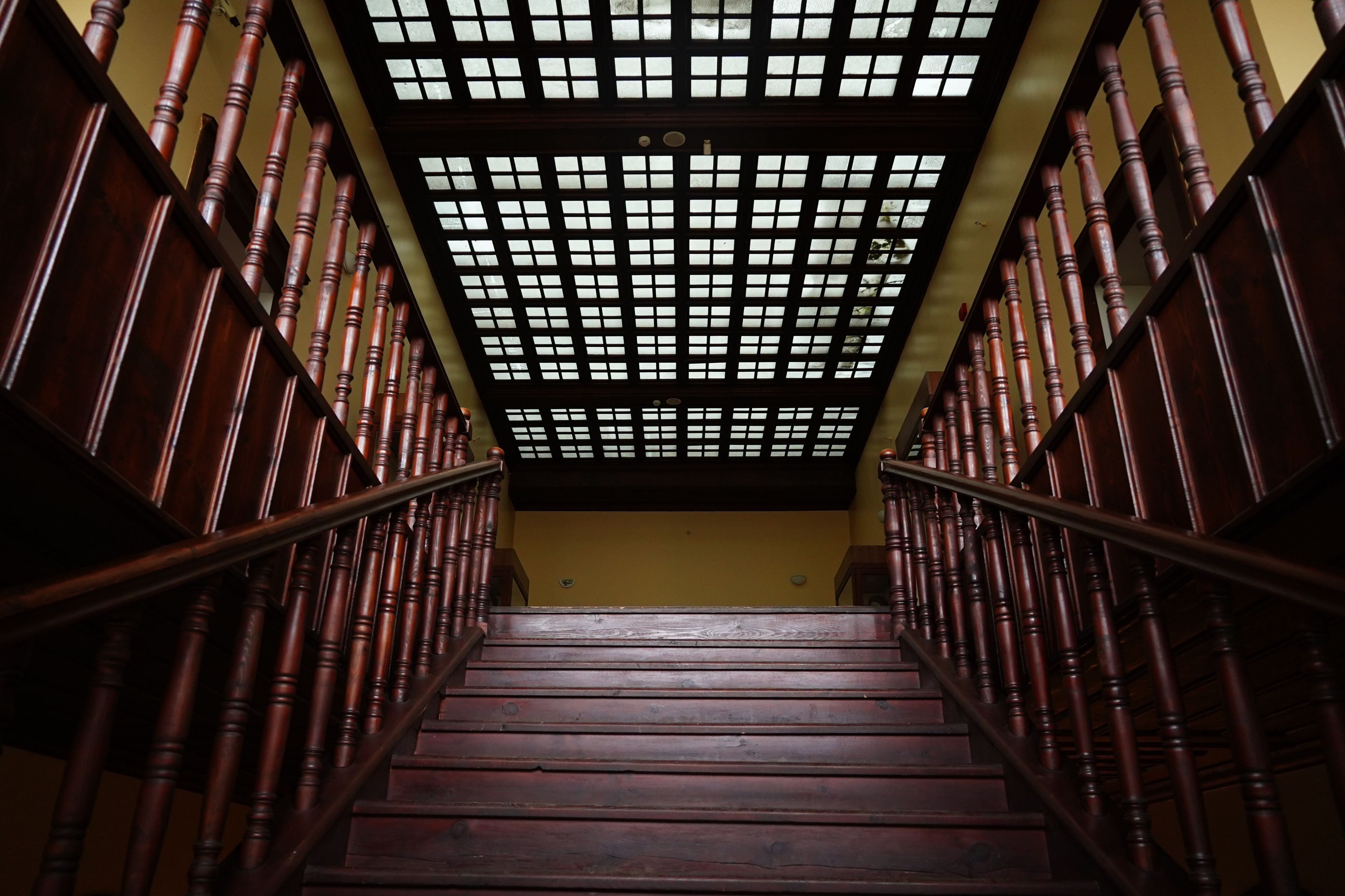 Elegant wooden staircase beneath a grid ceiling in a vintage home